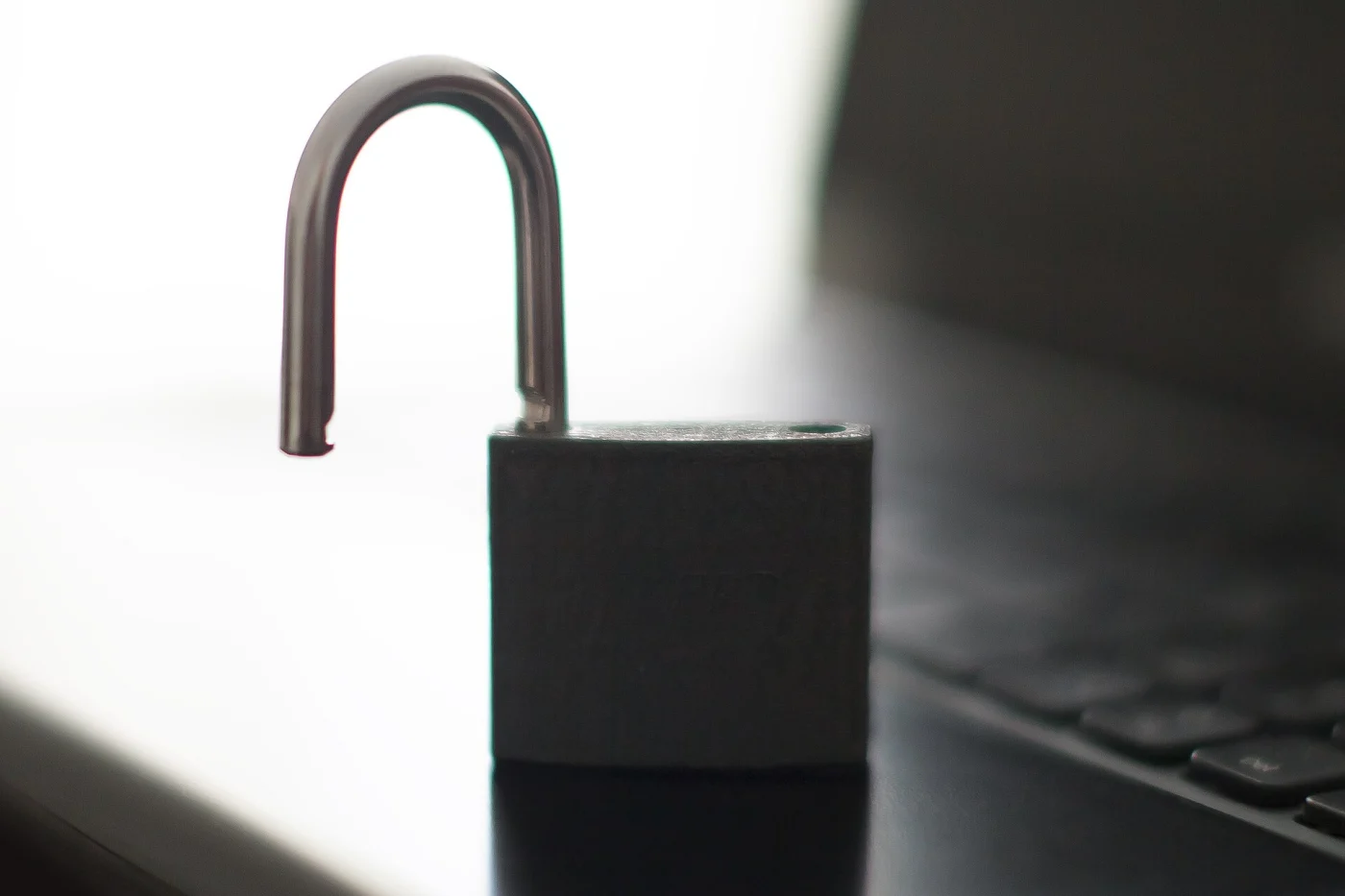 Cadenas ouvert posé à côté du clavier d'un ordinateur portable