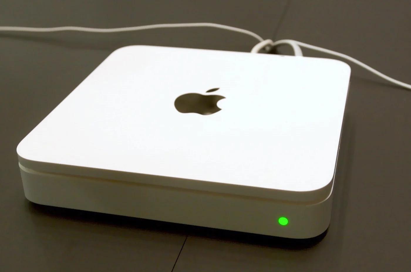 Borne AirPort Time Capsule posée sur un bureau, voyant vert allumé